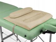 Beige brysthulspude med udskæring lagt oven på en massagebriks